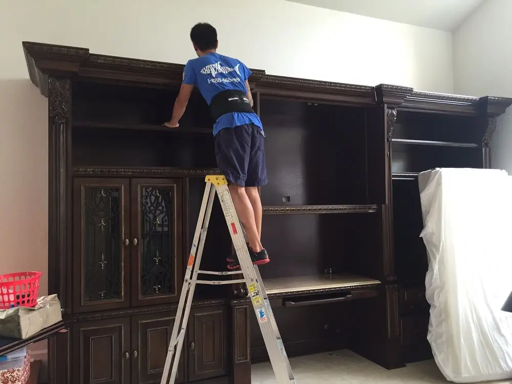 A man standing on a ladder in a room.