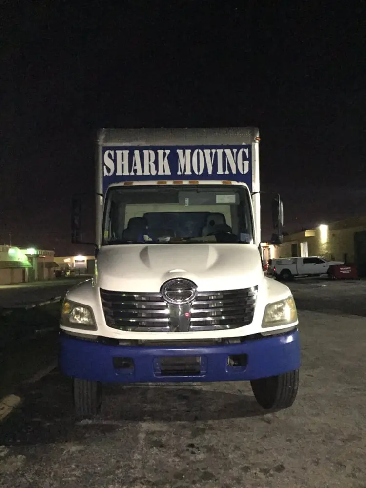 A Shark truck parked in a parking lot at night.