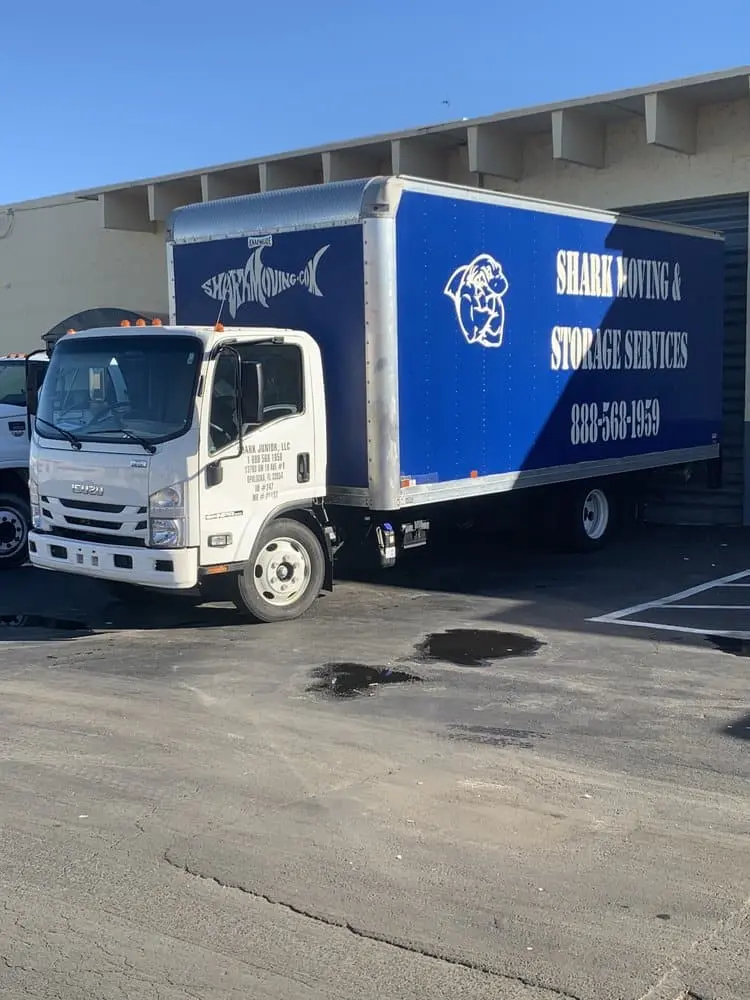 a blue and white truck parked in a parking lot.